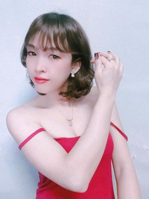 Woman with a short bob in a red dress posing for a video chat