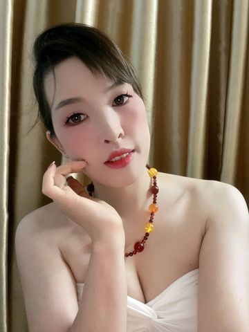 Woman resting her chin on her hand, laughing during a cam to cam chat