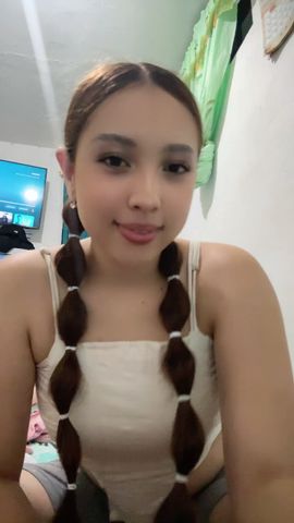 Woman with playful pigtails waving to a stranger on video chat